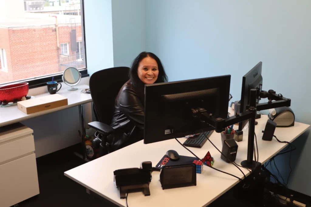 Techital employee working at desk smiling